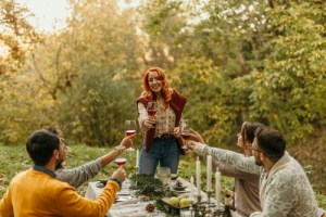 People eating dinner and cheering with wine