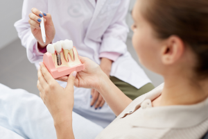 Dentist showing patient option for replacing missing teeth
